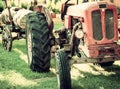 An old red tractor near a farm field. Royalty Free Stock Photo