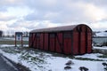 Old red train wagon on a snowy field and clouded sky Royalty Free Stock Photo