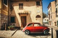 Old red vintage car italian scene in the historic center of small village in Italy. Elba Island, Marina di Campo city. Retro Royalty Free Stock Photo