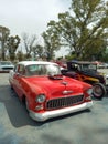 Old red and white 1955 Chevrolet Chevy Bel Air custom lowrider in a park. AAA 2022 classic car show