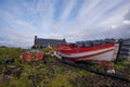 Old red and white fishing boats among beach clutter Royalty Free Stock Photo