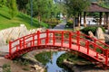 Old red wooden bridge across small river in Japanese park. Vintage style Japanese bridge above water. Uman, Ukraine summer, spring Royalty Free Stock Photo