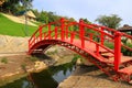 Old red wooden bridge across small river in park. Vintage Japanese style bridge, water. Uman park, Ukraine Royalty Free Stock Photo