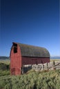 Old red wooden building in Montana USA with roof in form of arc and a fence around Royalty Free Stock Photo