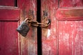 Old red wooden door closed with padlock and rusty old chain Royalty Free Stock Photo