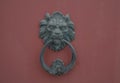 Old red wooden door with metallic ancient door handlÃÆ and knocker in the lion shape close-up. Exterior design