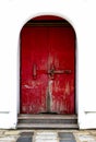 Old Red wooden door with peeling paint and a large locked wooden. Royalty Free Stock Photo