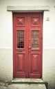 Old red wooden door with window and grid. Toned Royalty Free Stock Photo