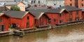 Old red wooden houses on the river coast on a cloudy day Royalty Free Stock Photo