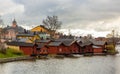 Old red wooden houses on the river coast on a cloudy day Royalty Free Stock Photo