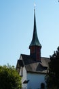 Old reformed church building in Urdorf, Switzerland among trees, lateral view with detail of the church tower