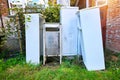 Old refrigerators under a building. A dump of abandoned household appliances Royalty Free Stock Photo