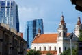 An old religious building, a cathedral, against tall buildings belonging to modern architecture Royalty Free Stock Photo