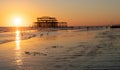 The old remains of Brighton Pier left standing in sea with beautiful waves and seagulls on the beach. Royalty Free Stock Photo