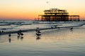 The old remains of Brighton Pier left standing in sea with beautiful waves and seagulls on the beach. Royalty Free Stock Photo