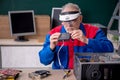 Old repairman repairing computers in the classroom Royalty Free Stock Photo