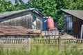 Old residential building in nature with water barrels on the roof. domestic water supply Royalty Free Stock Photo