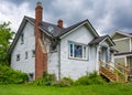 Old residential house with brick chimney and neglected lawn on the front Royalty Free Stock Photo