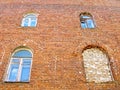 Old residential house, brick wall, arched windows, one bricked up window Royalty Free Stock Photo