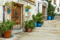 Old residential houses in medieval style with wood doors, terracota and blue flowerpots, staircase, Alicante Santa Cruz