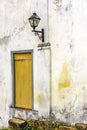 Old residential lighting lantern next to a aged and anciente wooden window Royalty Free Stock Photo