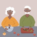 Old retired black afro american couple cook together a vegetable salad on the table