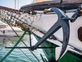 Old retro anchor tied with steel chain and ropes from an old ship in the harbour Royalty Free Stock Photo