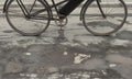 Old retro bicycle on wet cracked asphalt with pits and puddles on a cloudy rainy day. 3D rendering illustration