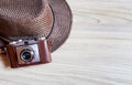 Old retro camera with brown vintage hat on wooden boards abstract background with copy space Royalty Free Stock Photo