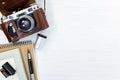 Old retro camera in leather cover, notebook, pen, and roll film Royalty Free Stock Photo