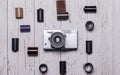 An old retro camera and pieces of photographic film lie on a wooden table. View from above