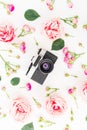 Old retro camera and roses, buds and leaves on white background. Flat lay, top view. Vintage background. Royalty Free Stock Photo