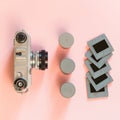 Old retro camera with three box for film and some slides on pink background. Royalty Free Stock Photo