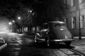 Old retro car stay on asphalt city road at rainy night Royalty Free Stock Photo