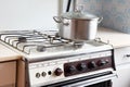 Old retro gas stove with pans and kettle. photo of obsolete kitchen utensils. Royalty Free Stock Photo