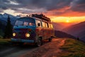 Old retro hippie camper home on wheels in the mountains at sunset, with warm glow over sky.