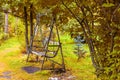An Old Retro Iron Wrought Metal Swing With A Wooden Bench In A Vintage Style Stands In A Garden Or Park For Children`s