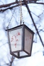 Old retro lantern with a pattern hanging on a chain in the garden Royalty Free Stock Photo