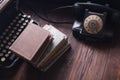 Old retro phone with vintage typewriter and books on wooden board Royalty Free Stock Photo