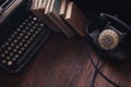 Old retro phone with vintage typewriter and books on wooden board Royalty Free Stock Photo