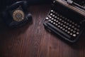 Old retro phone with vintage typewriter on wooden board Royalty Free Stock Photo