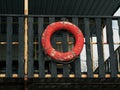 Old retro red lifebuoy hanging on wooden balcony. Help, rescue concept. Vintage life saver on the beach house Royalty Free Stock Photo
