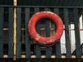 Old retro red lifebuoy hanging on wooden balcony. Help, rescue concept. Vintage life saver on the beach house