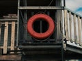 Old retro red lifebuoy hanging on wooden balcony. Help, rescue concept. Vintage life saver on the beach house Royalty Free Stock Photo