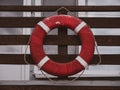 Old retro red lifebuoy hanging on wooden balcony. Help, rescue concept. Vintage life saver on the beach house