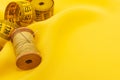 Old retro sewing accessories lie on a yellow fabric. Needle and thread Royalty Free Stock Photo
