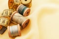 Old retro sewing accessories lie on a yellow fabric. Needle and thread Royalty Free Stock Photo