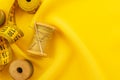 Old retro sewing accessories lie on a yellow fabric. Needle and thread Royalty Free Stock Photo