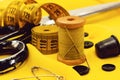 Old retro sewing accessories lie on a yellow fabric. Needle and thread Royalty Free Stock Photo