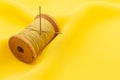 Old retro sewing accessories lie on a yellow fabric. Needle and thread Royalty Free Stock Photo